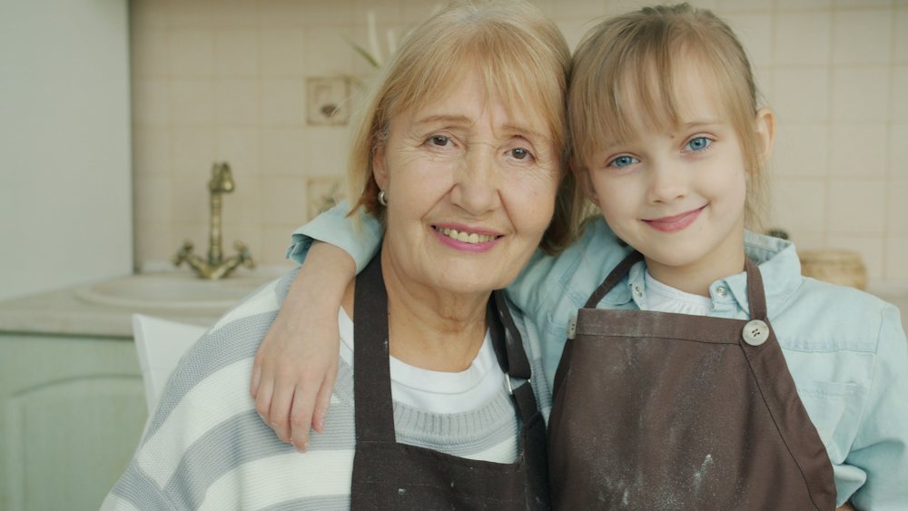 Grandmother and granddaughter smiling at home